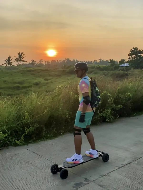 Merald Ayson on an electric skateboard at sunset